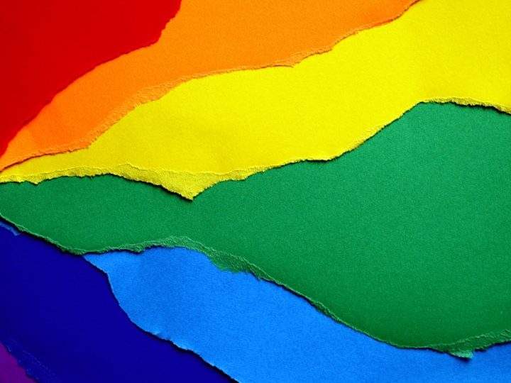 Bunte Papierschnipsel in Regenbogenfarben mit geschwungenen Kanten.