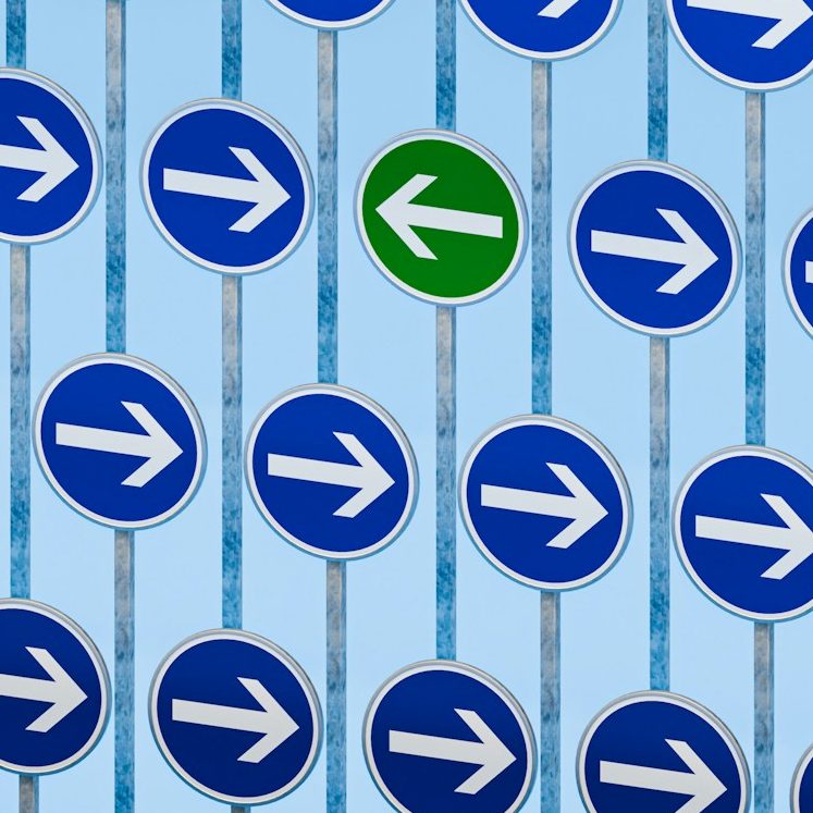 Ein Muster aus blauen Verkehrsschildern mit nach rechts zeigenden Pfeilen und einem grünen Pfeil nach links.